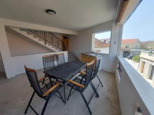 a table and chairs in a kitchen with a staircase at Apartments Božena in Pakoštane