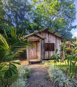 ein kleines Holzgebäude inmitten eines Gartens in der Unterkunft Citronela Lodge Corcovado in Drake