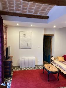 Saint-Florent-sur-AuzonnetにあるCharmant logement dans les Cevennesのリビングルーム(ベッド1台、赤い敷物付)