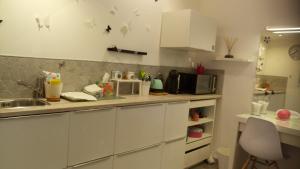 a kitchen with white cabinets and a sink and a microwave at Dépendance privée avec entrée autonome in Toulouse