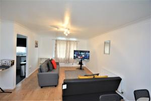 a living room with a couch and a flat screen tv at Spacious Two-Bedroom Apartment in Dagenham