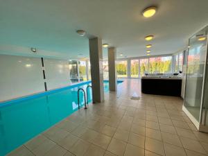 a large swimming pool in a building with a swimming pool at Wellness Dorina in Siófok