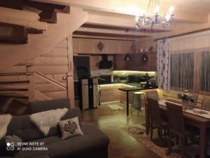 a living room and kitchen with a couch and a table at Domek Jurgów 406 in Jurgów