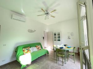 un soggiorno con divano verde e tavolo di Casa Palma a 100 passi dal mare a Marina di Ragusa