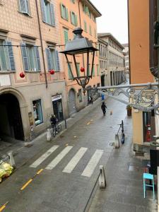 uma rua da cidade vazia com uma luz de rua e edifícios em La Castellana Loft Hotel em Bérgamo