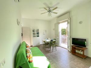 a living room with a couch and a television and a table at Casa Palma a 100 passi dal mare in Marina di Ragusa