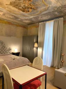 1 dormitorio con cama, mesa y techo en La Castellana Loft Hotel, en Bérgamo