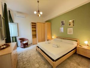 a bedroom with a large bed and a desk at Casa Palma a 100 passi dal mare in Marina di Ragusa