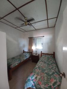 1 dormitorio con 2 camas y ventilador de techo en Jazmín, en Aguas Dulces
