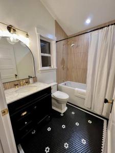 a bathroom with a toilet and a sink and a bath tub at Brand New Custom Built Cottage in Downtown w/Pool! in Salem