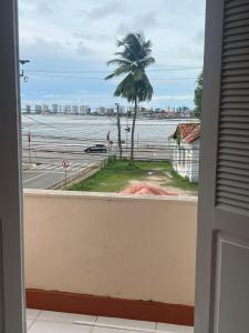 a view of the ocean from a balcony with a palm tree at Hostel dos Poetas in São Luís