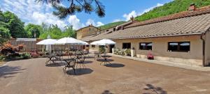 patio ze stołami, krzesłami i parasolami w obiekcie Locanda Le Panche w mieście Pistoia