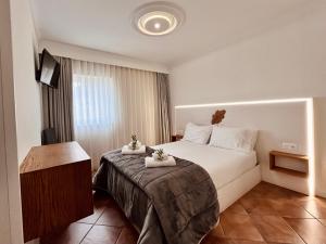 um quarto de hotel com uma cama com toalhas em BHDouro em Baião
