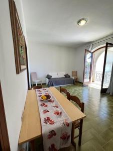 a room with a table and a bedroom with a bed at Maison Umberto I a Villasimius centro in Villasimius