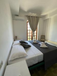 a large bed in a room with a window at Maison Umberto I a Villasimius centro in Villasimius