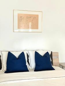 uma cama com almofadas azuis e uma fotografia por cima em Cosy apparemment em Lausanne