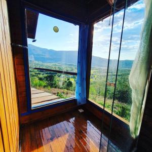 a room with a large window with a view at Pousada Refúgio das Montanhas in Praia Grande