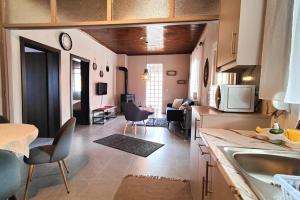 cocina y sala de estar con mesa y sillas en Home Of Irini en Komniná