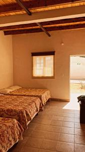 two beds in a room with a window at Catorce Capital A una HORA de Real de Catorce in Estación Catorce