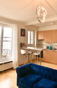 a living room with a blue couch in a kitchen at Cosy apparemment in Lausanne