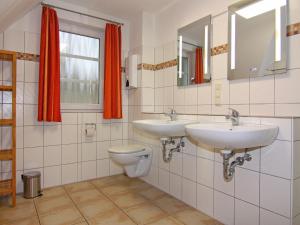 a bathroom with two sinks and a toilet at Doppelhaushälfte Ostseehaus II, Trassenheide in Trassenheide +35 photos