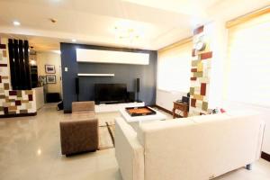 a living room with a white couch and a fireplace at 3 Bedroom in Tuscany Private Estate BGC in Manila