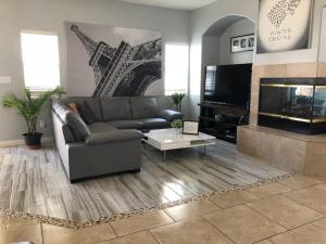 a living room with a couch and a flat screen tv at Oasis pool house, optional pool heater in Las Vegas