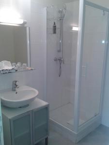 uma casa de banho branca com um chuveiro e um lavatório. em Les app'ART - Le Havre Centre St Joseph em Le Havre