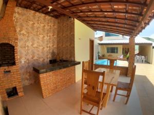 a dining room with a table and a brick fireplace at Casa praia Família Barbosa, com piscina in Luis Correia