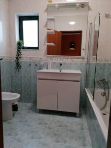 ein Badezimmer mit einem Waschbecken, einem WC und einer Badewanne in der Unterkunft Apartamento Nora in Lagos
