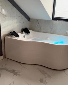 a white bath tub in a bathroom with marble walls at BALA HOTEL in Tuzla