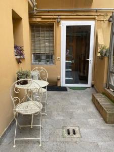 un patio con mesa y sillas frente a una puerta en Casina Centotrecento-Romantic & Quite Apartment-, en Bolonia