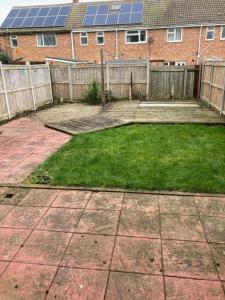 a backyard with a yard with some grass and solar panels at Tempest House 3 bedroom in Hartlepool