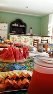 une table garnie d'assiettes de pastèques et de tartes dans l'établissement Pousada Primavera, à Parati