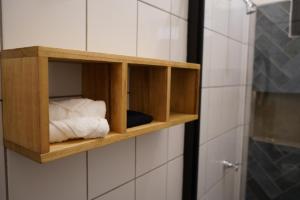 a wooden shelf on a bathroom wall with towels at Hotel Kraken in Salinas