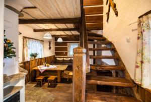 a dining room with a wooden table and a staircase at Domki Osada Werdołyna in Polańczyk