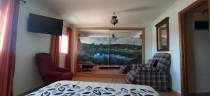 a bedroom with a large painting of a lake at Luz de Carboneras in Carboneras de Guadazaón