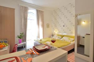 Un dormitorio con una cama y una mesa con una copa de vino en Studio Burić, en Pula