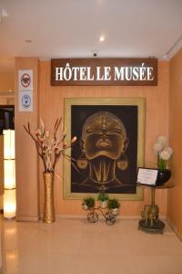 a hotel lobby with a picture of a head on the wall at Hotel Le Mus&eacute;e in Rabat