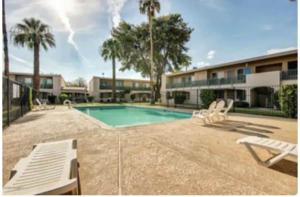 a swimming pool with chairs and a building at Modern Villa in Old Litchfield in Litchfield Park