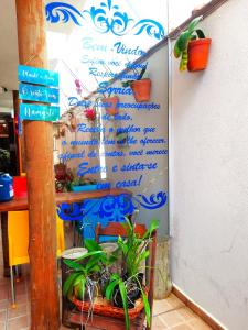 eine Wand mit Schildern und Pflanzen darauf in der Unterkunft Pousada Estrela Mare in São Sebastião