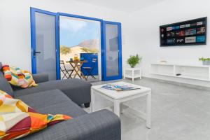 a living room with two couches and a table at Apartamento Dunas De Famara in Famara