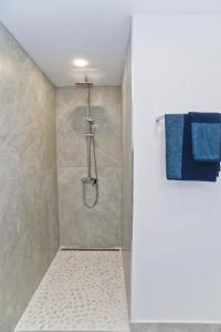 y baño con ducha y toallas azules. en Apartamento Dunas De Famara, en Famara