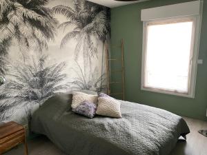 a bedroom with a bed with a tropical wallpaper at Appartement pour les 24 heures in Le Mans