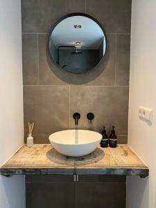 a bathroom with a white sink and a mirror at Zilt Noordwijk in Noordwijk aan Zee