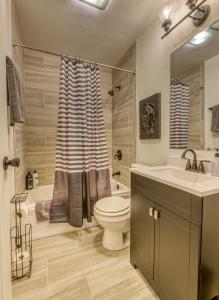 een badkamer met een toilet, een wastafel en een douche bij Modern Beach Bungalow, Firepit, Foosball, Hot tub, IN Dunes Natl Park in Miller