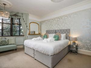 - une chambre avec un grand lit et des serviettes dans l'établissement The Chestnuts, à Peterborough