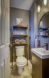 a bathroom with a white toilet and a sink at Modern Beach Bungalow, Firepit, Foosball, Hot tub, IN Dunes Natl Park in Miller +12 photos