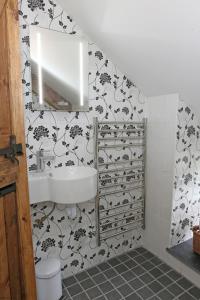 a bathroom with a sink and black and white wallpaper at Snuggle hot tub Dolgoy in Blaencelyn