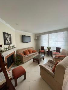 sala de estar con sofás y TV de pantalla plana. en Acogedor apartamento en norte - 2 habitaciones, en Bogotá